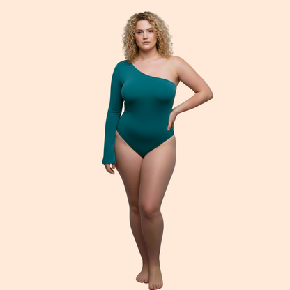 Woman wearing a teal one-shoulder bodysuit on a beige background