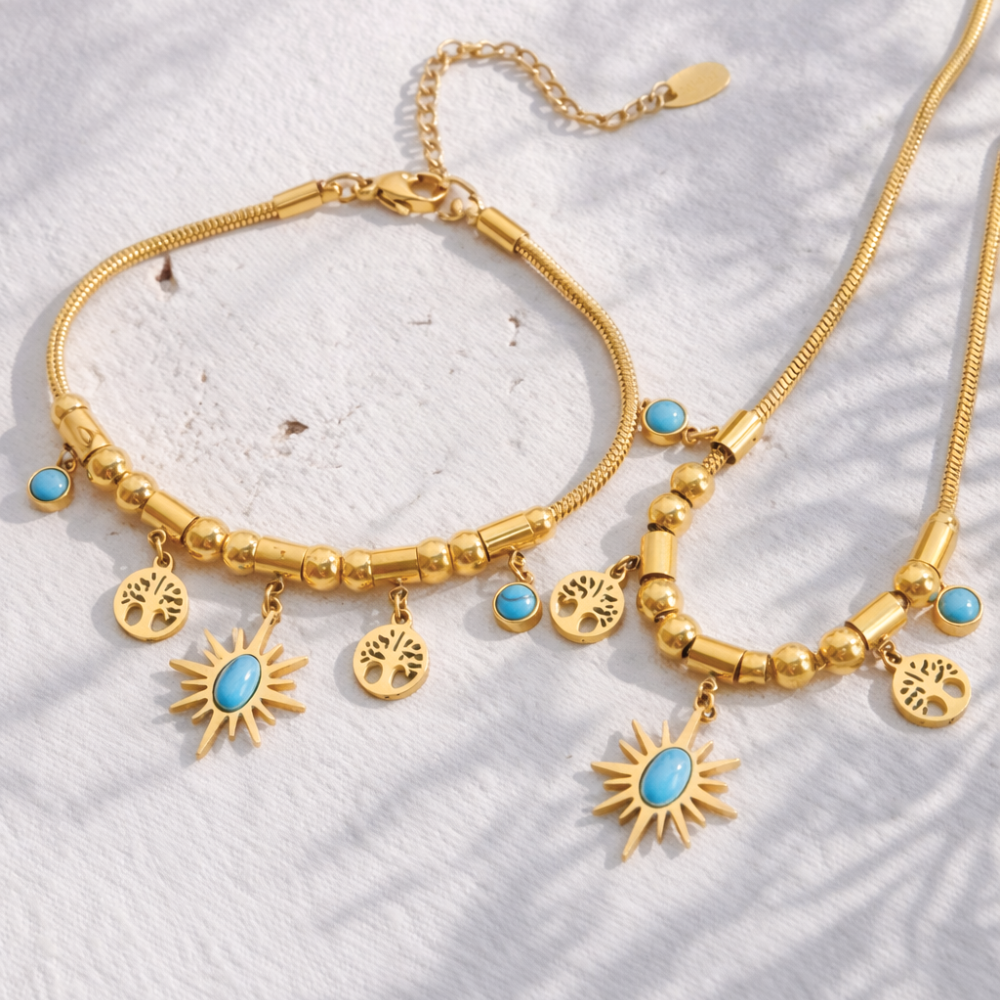 Gold bracelet with turquoise stones on a textured white surface